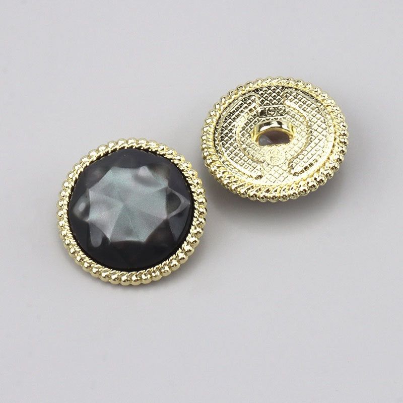 Black resin round button with gold filigree border and alloy shank; front and back