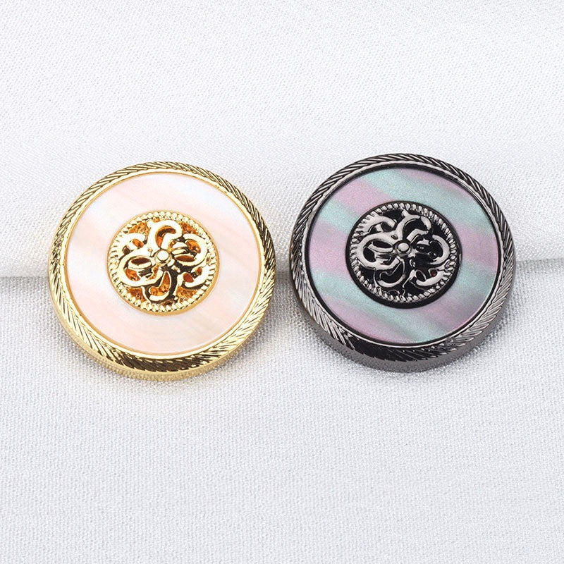 Gold and gunmetal resin metal coat buttons side by side, ornate floral emblems
