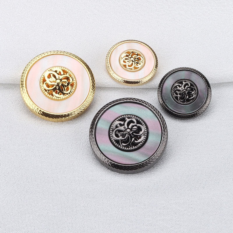 Set of gold and gunmetal resin metal coat buttons with ornate center emblems, 4 shown