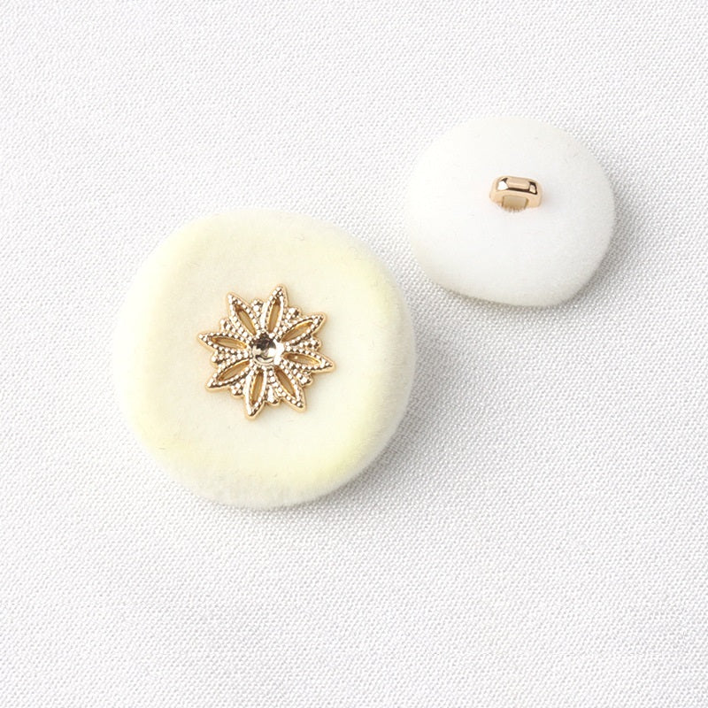 Off-white flocked coat button with gold snowflake front and metal shank back
