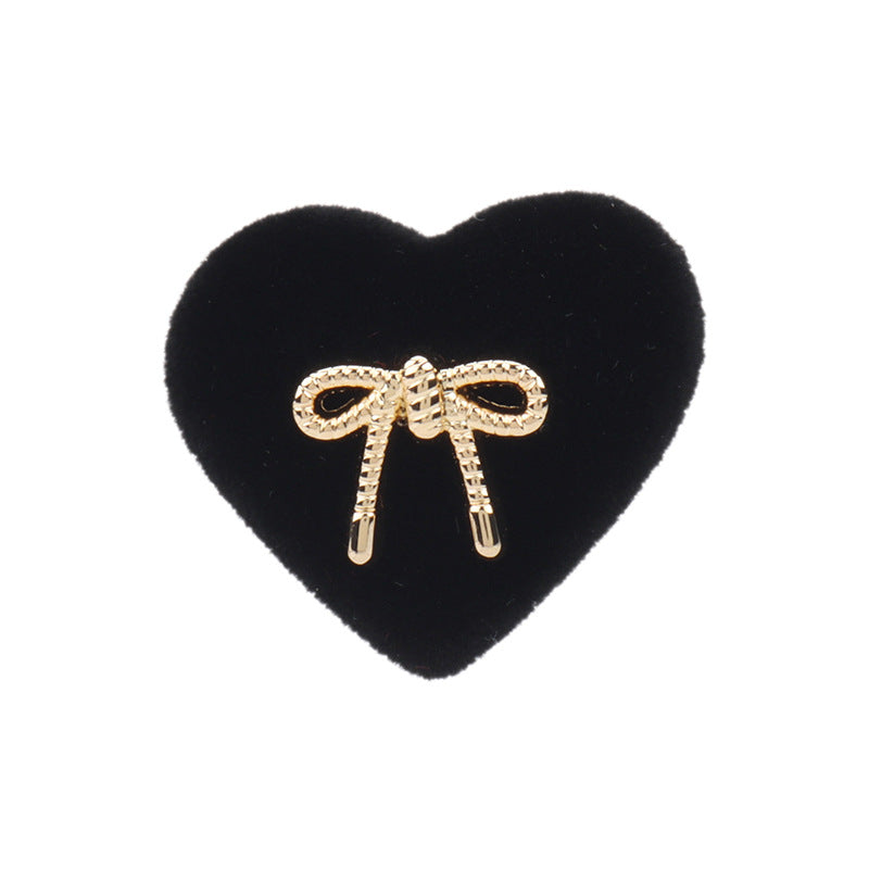Black heart-shaped velvet shank button with rhinestone bow detail and two prongs