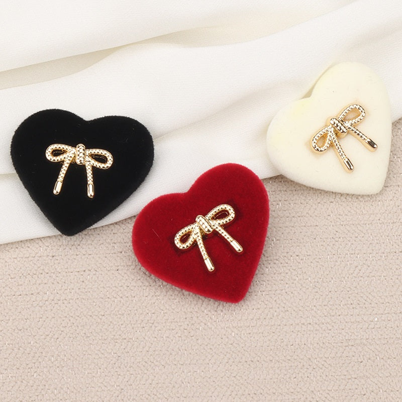 Heart-shaped shank buttons in black, red, and white with rhinestone bows and prongs