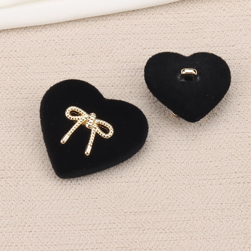 Black heart-shaped velvet shank buttons showing flat loop on the back