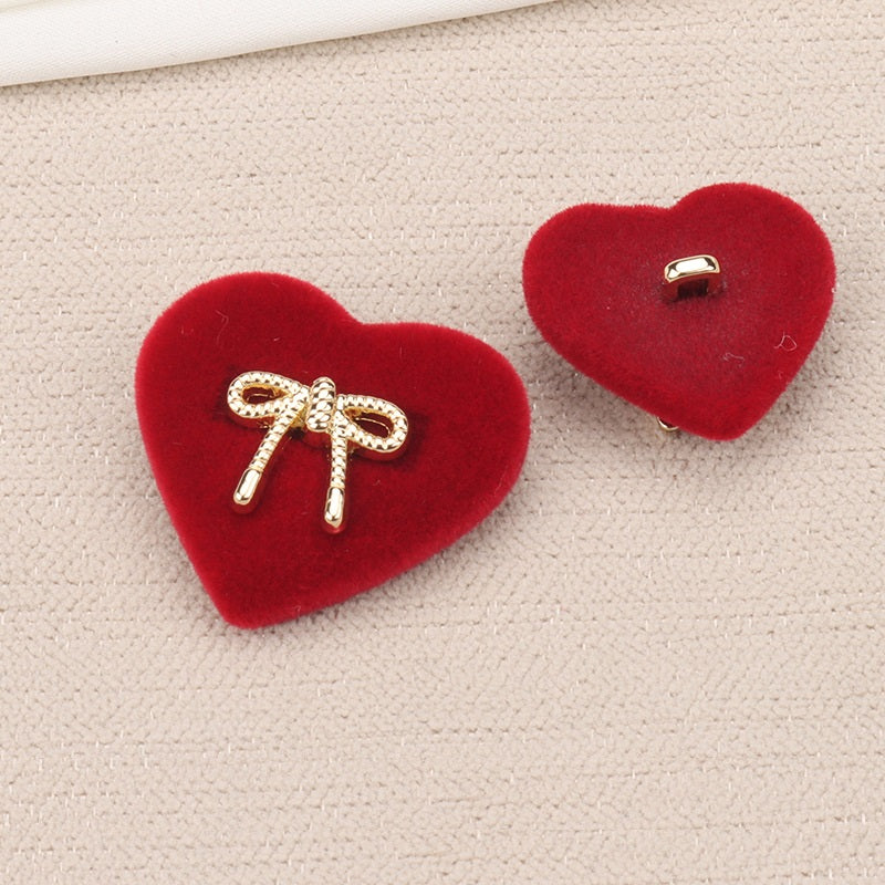 Red heart-shaped velvet shank button with rhinestone bow and two prongs