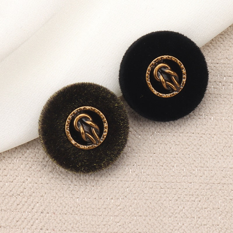 Black and brown flocked metal combination buttons, gold logo centers, on fabric