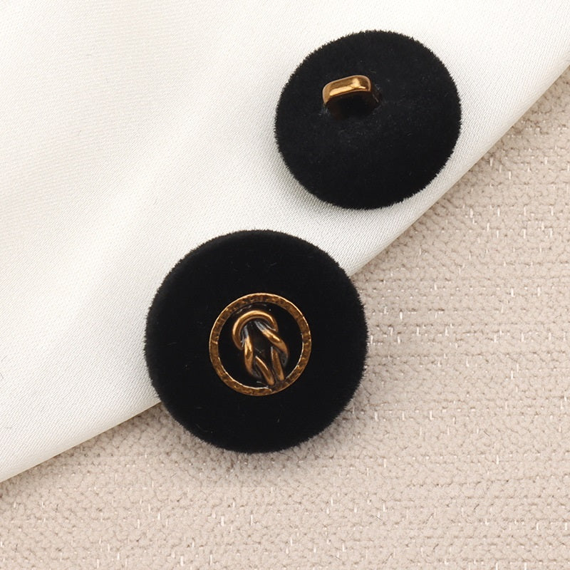 Black flocked metal combination button with gold ring logo, front view