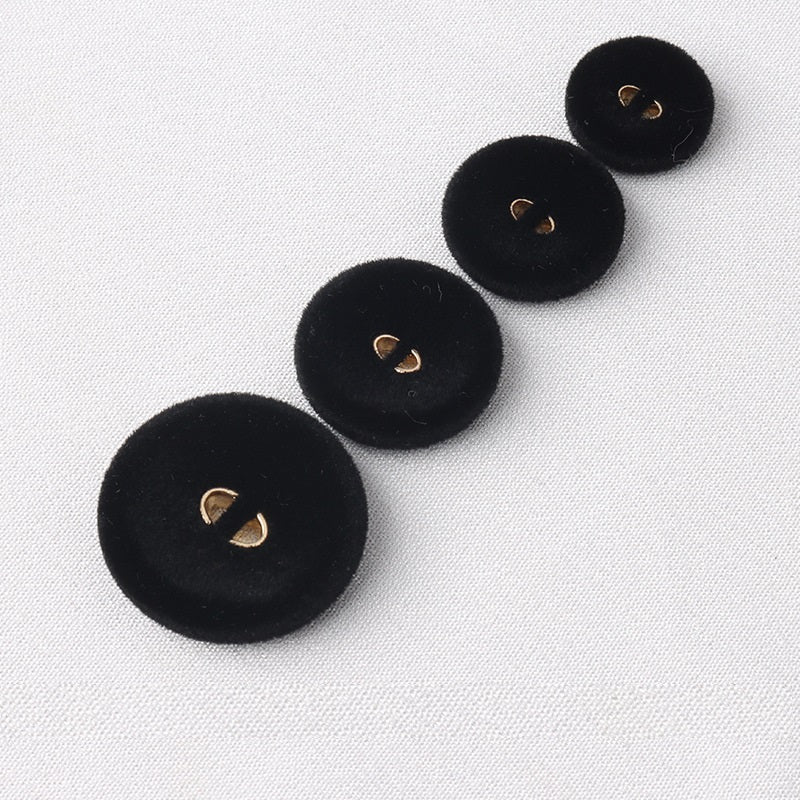 Set of round black flocked coat buttons with two gold-tone holes