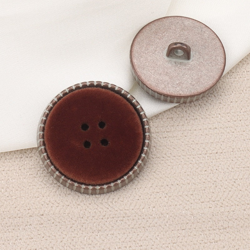Round dark brown flocked coat button with shank and 4-hole design, metal back visible