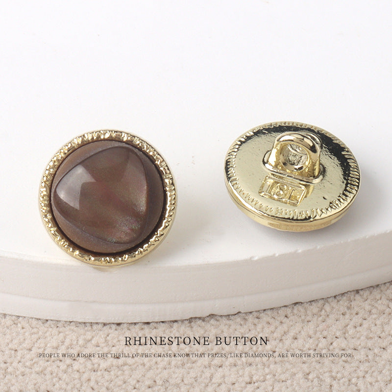 Brown resin-look 11mm button with gold rim and gold metal back, snap shank visible