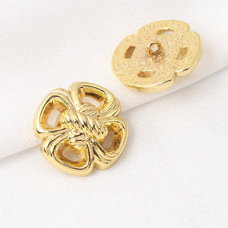 Vierblättriges Kleeblatt-Design: goldfarbener Metallknopf mit Schaft, Vorder- und Rückseite sichtbar