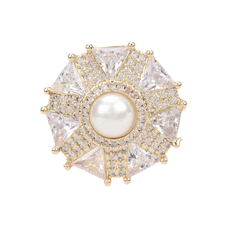Umbrella-shaped coat button with goldtone rim, round pearl center, and crystal rhinestones