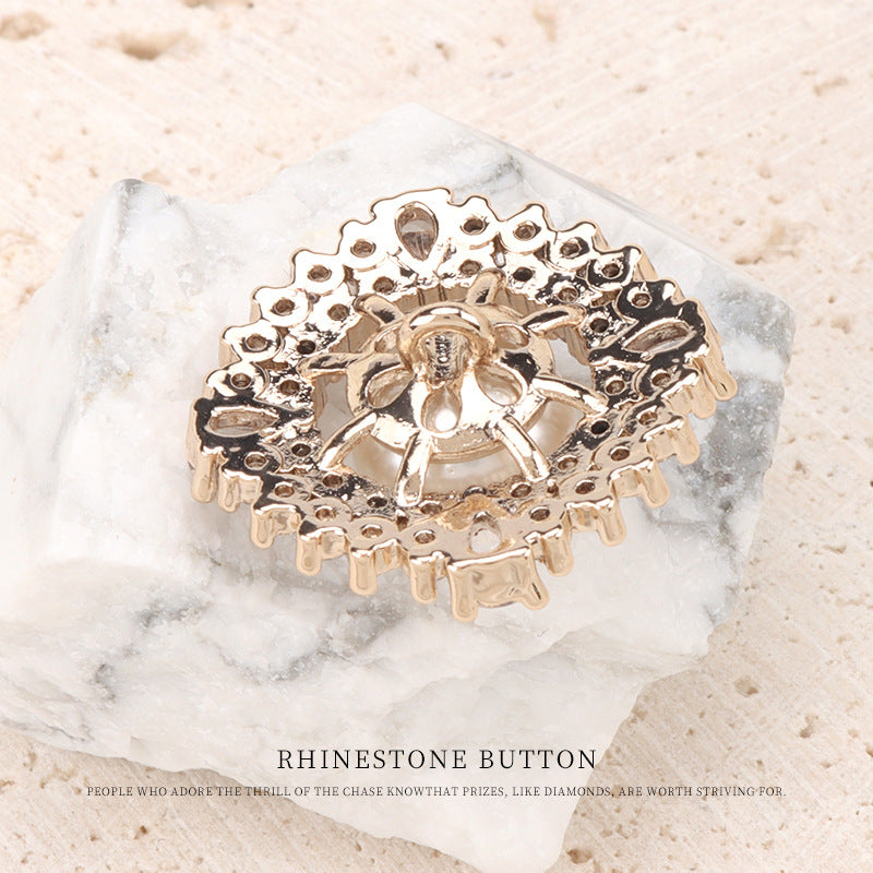 Back of rhinestone pearl button with gold-tone metal setting and pin