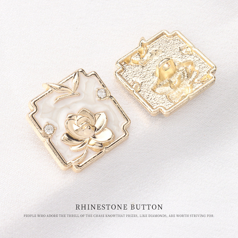 Square metal shank button front in white enamel with gold lotus and crystal accents; gold back