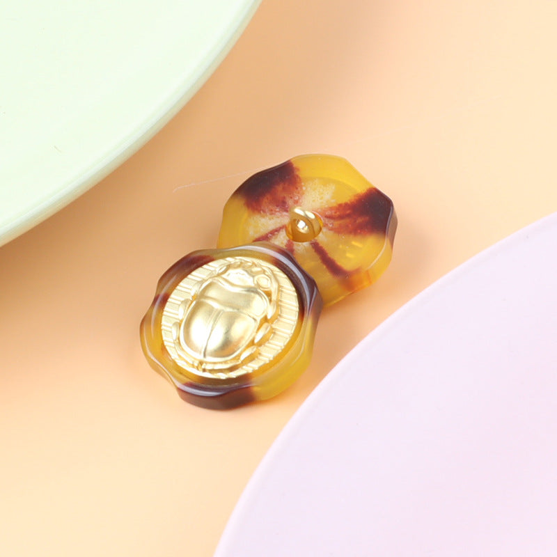 Metal shank buttons: amber marbled scarab beetle relief, Roman head pattern (15 pack)