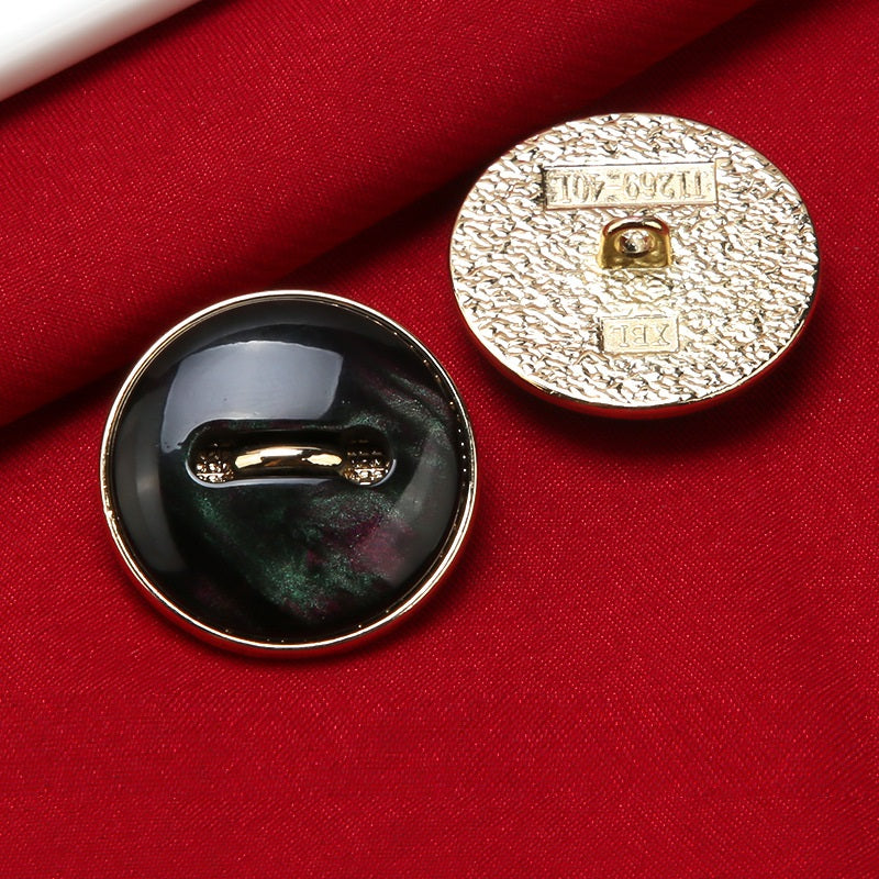 Schwarzer Harz-Mantelknopf mit goldfarbener Schaftöse und Metallrückseite mit Prägung