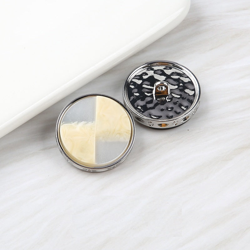 Fan-shaped two-tone resin buttons: cream/light beige and black speckled, metal shank