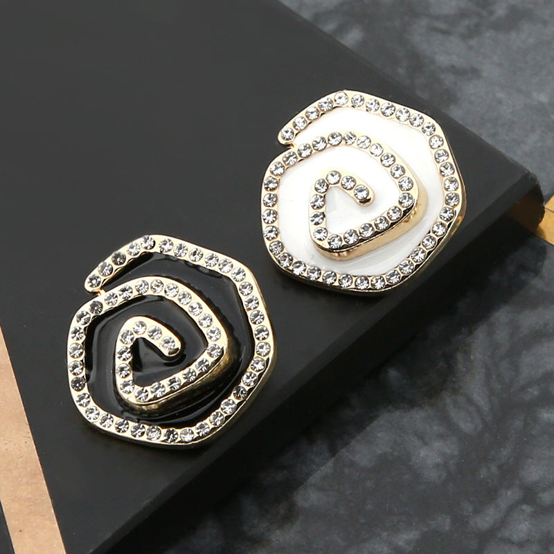 Pair of irregular curved metal buttons with rhinestones: white enamel and black enamel, gold-tone