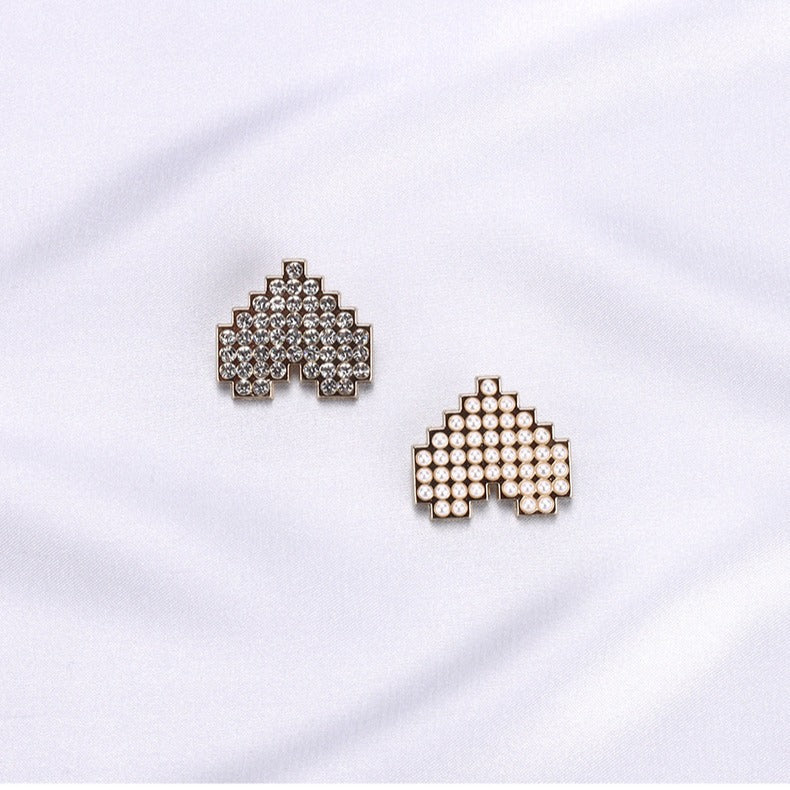 Two heart-shaped buttons: pearl-look and rhinestone, gold-tone frames