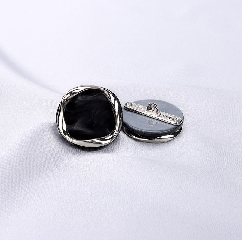 Black resin shank button with metal back and eyelet detail