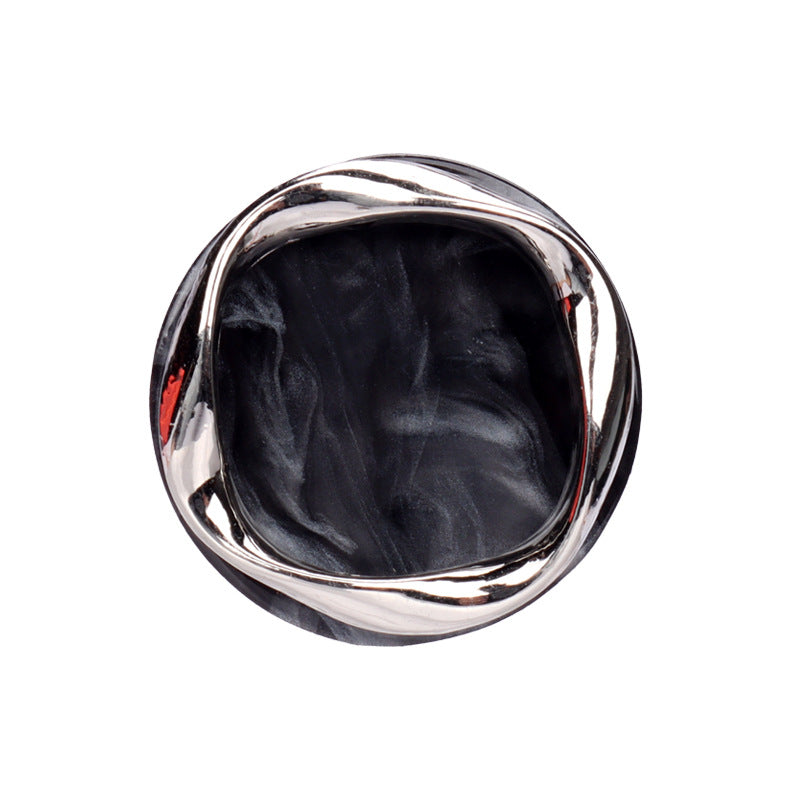 Black resin button with metal rim, shank side view