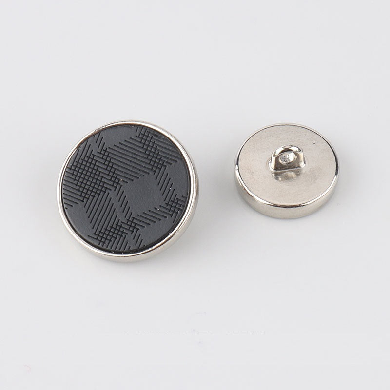 Round button back with metal shank and silver-tone rim; dark engraved front visible