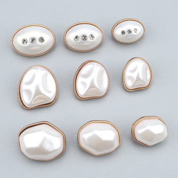 Oval pearl-look button with gold bezel and three clear rhinestones