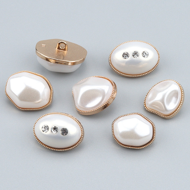 Oval pearl-look button with gold bezel and three rhinestones in a row