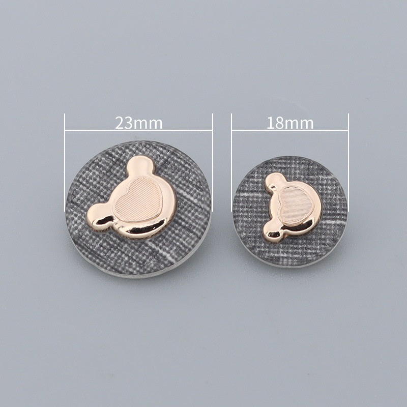 Bear-shaped metal buttons, sizes marked 23mm and 18mm on textured round backs