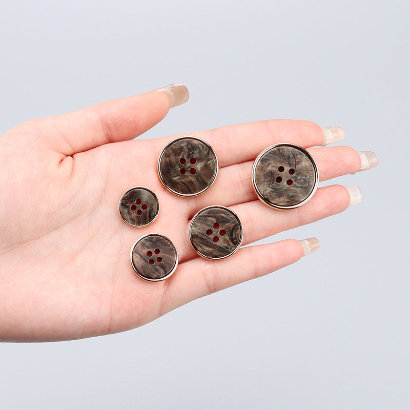 Four round four-hole buttons on palm, mixed metallic resin finishes with gold-tone edges