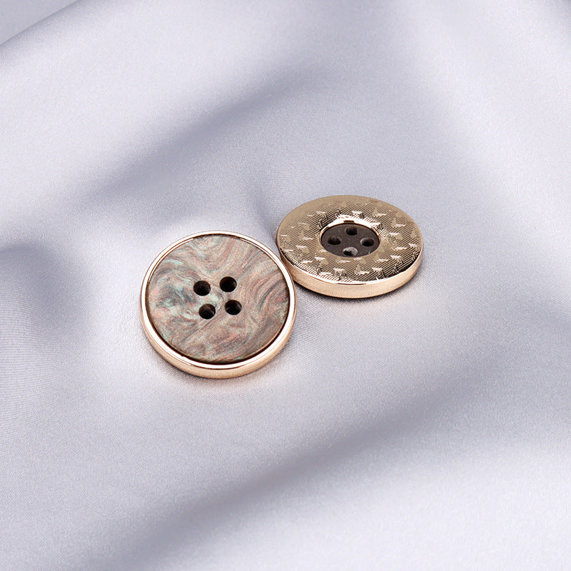 Two round four-hole buttons with gold metal rims, light-gray and dark mottled resin faces