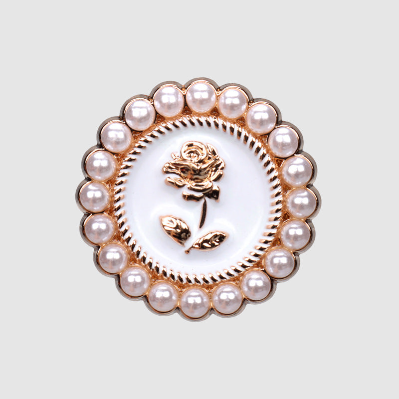 Close-up pearl rose metal button with white center and gold rose-and-leaf motif