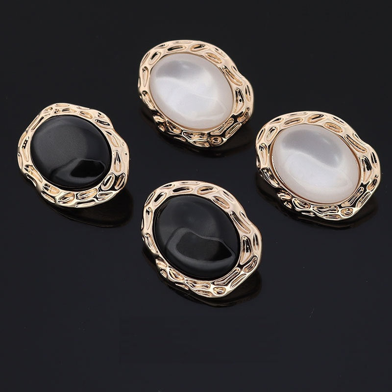 Set of white and black resin buttons with gold ornate oval frames and shanks