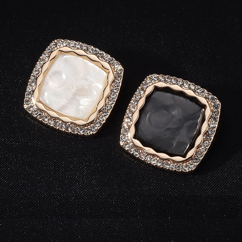 Square metal buttons: white and black centers, diamond-studded border