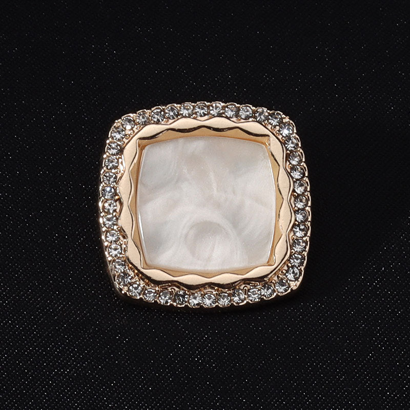 White square diamond-studded metal button with shank