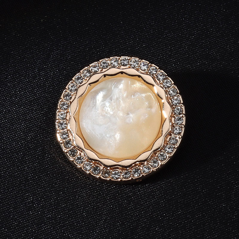 Pearl-look white round shank button with gold rim and clear rhinestone border