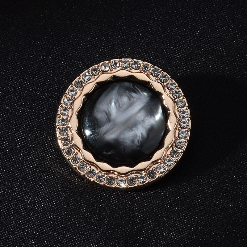 Black round shank button with gold rim and clear rhinestone border, domed center