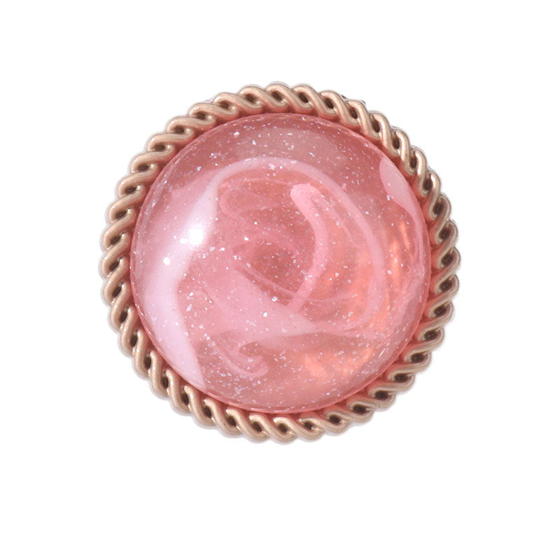 Pink resin alloy shank button, round with gold-tone rim, close-up