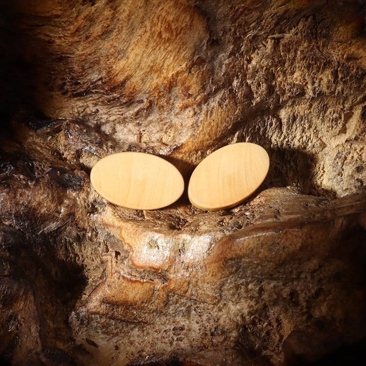 Two 15mm oval natural wood buttons with visible metal shanks and smooth backs