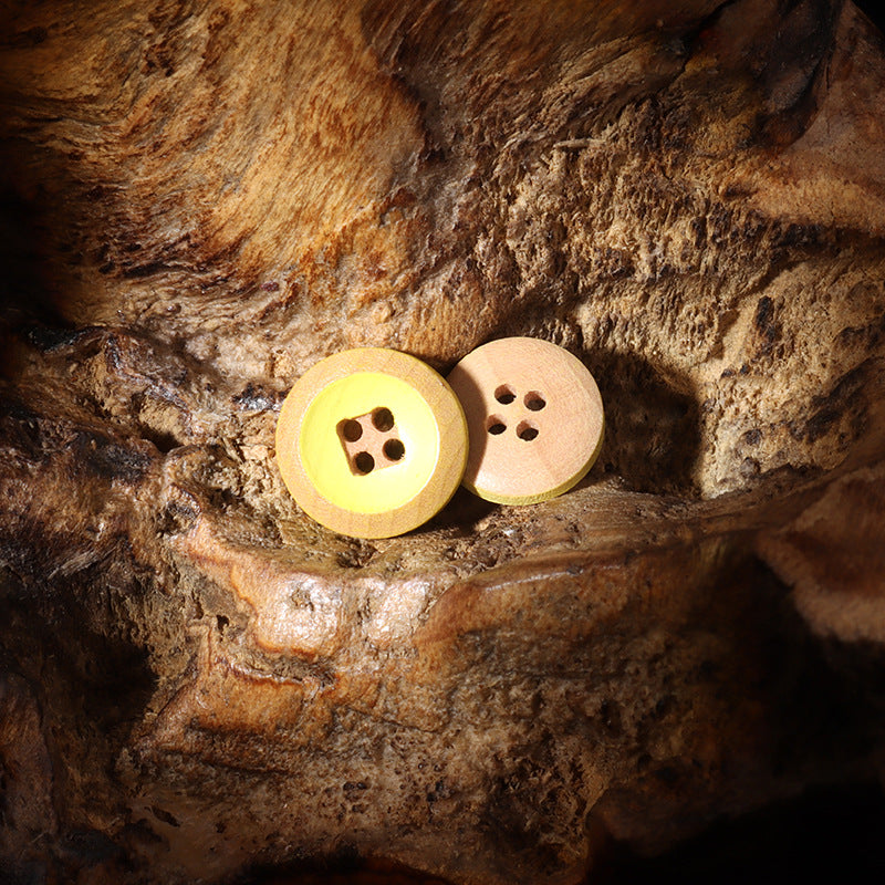 Pair of 4-hole round wooden buttons, one yellow-painted, one white-painted