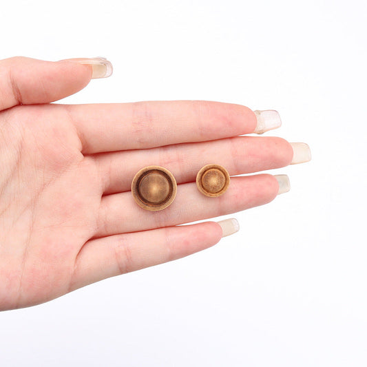 Deep brown round wood buttons with shanks, held in hand; 10/15mm