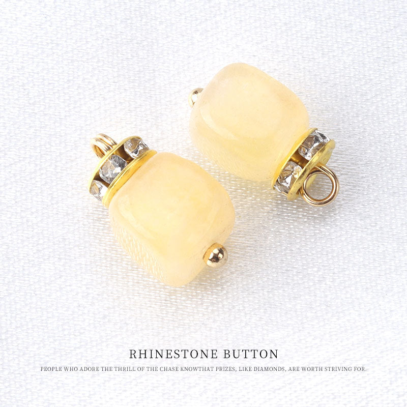 Yellow natural stone frog knot button with gold tone loop and rhinestone trim