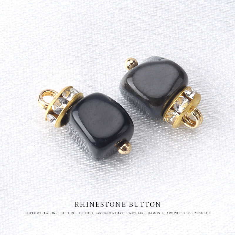 Black natural stone frog knot button with gold tone loop and rhinestone trim