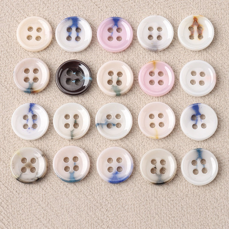 Glazed ceramic four-hole buttons: blue-white swirls on cream, pink, and gray