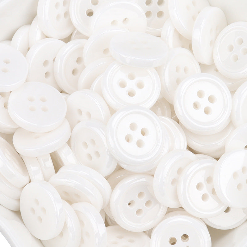 Overlapping white 4-hole ceramic buttons, top views