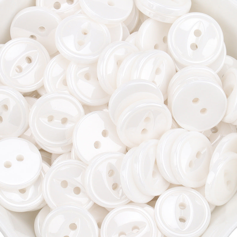 White 11.5mm ceramic buttons with four holes, assorted front views in pile