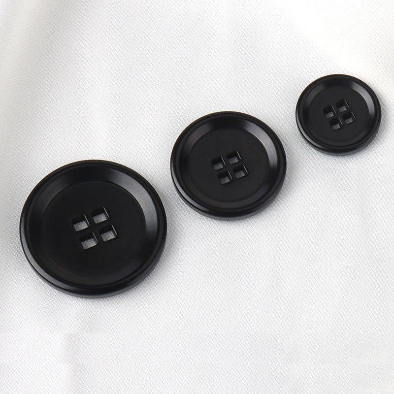 Black corozo-style buttons with square-hole cross, round front