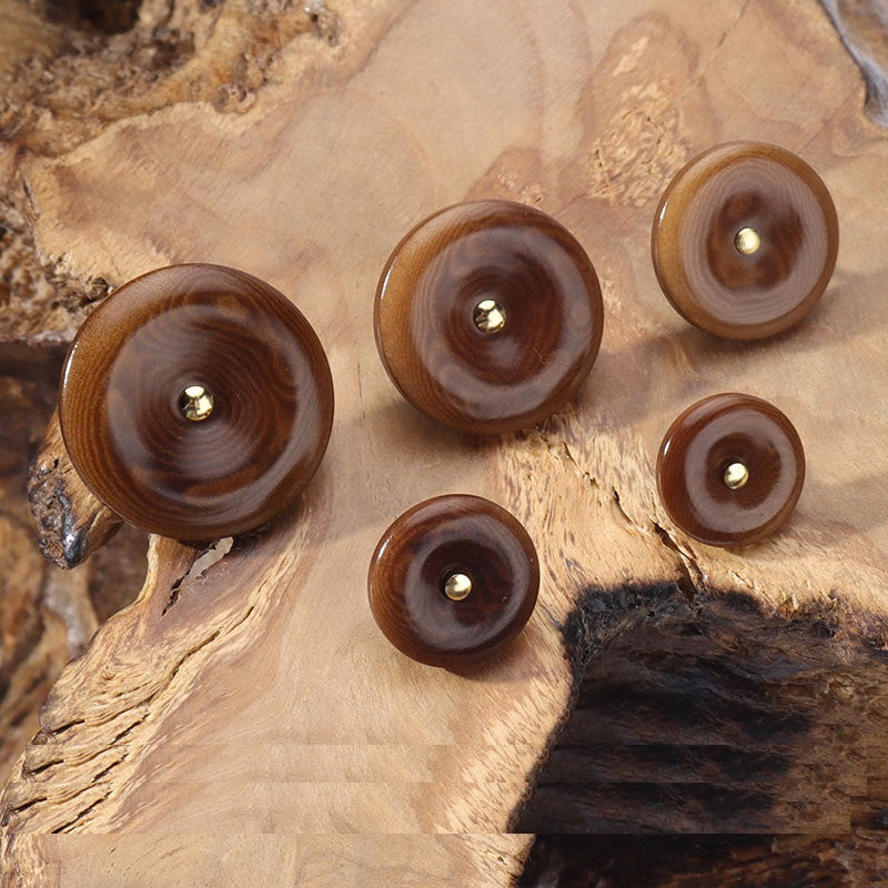 Coffee-brown corozo buttons with gold-toned loop shanks, round fronts