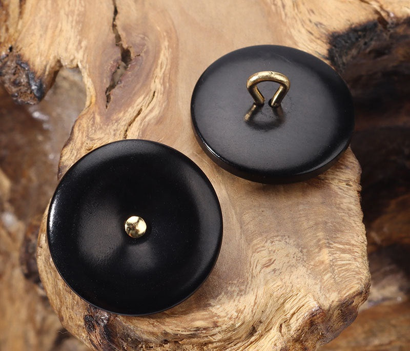 Black corozo buttons with gold-toned loop shanks, two round fronts