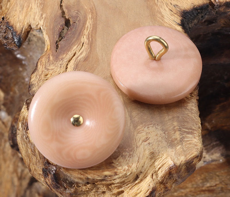 Pink corozo buttons with gold-toned loop shanks, two round fronts