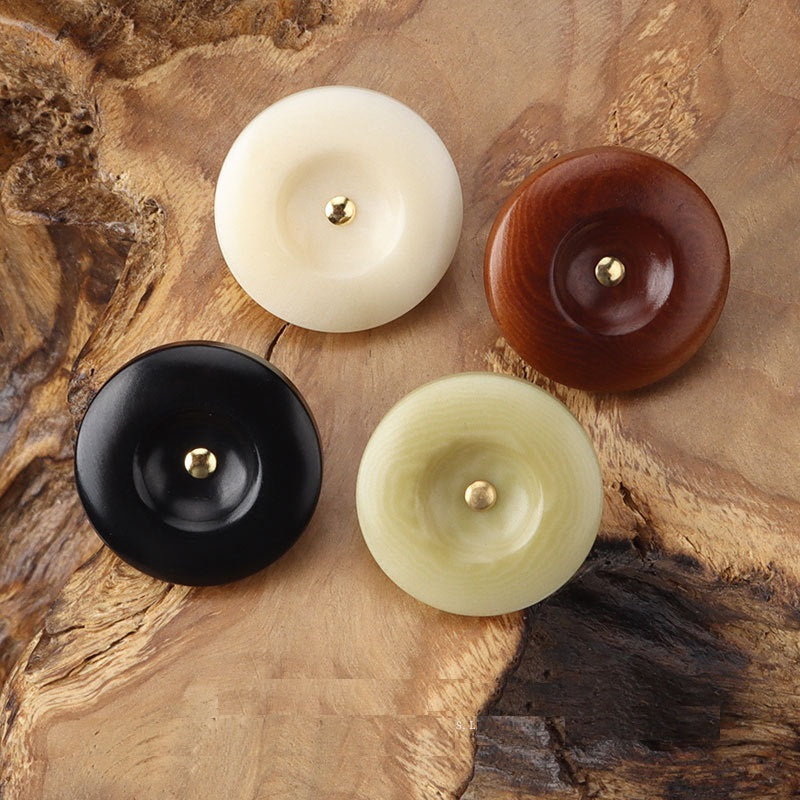 Beige, black, brown, and light green round corozo shank buttons with brass shanks
